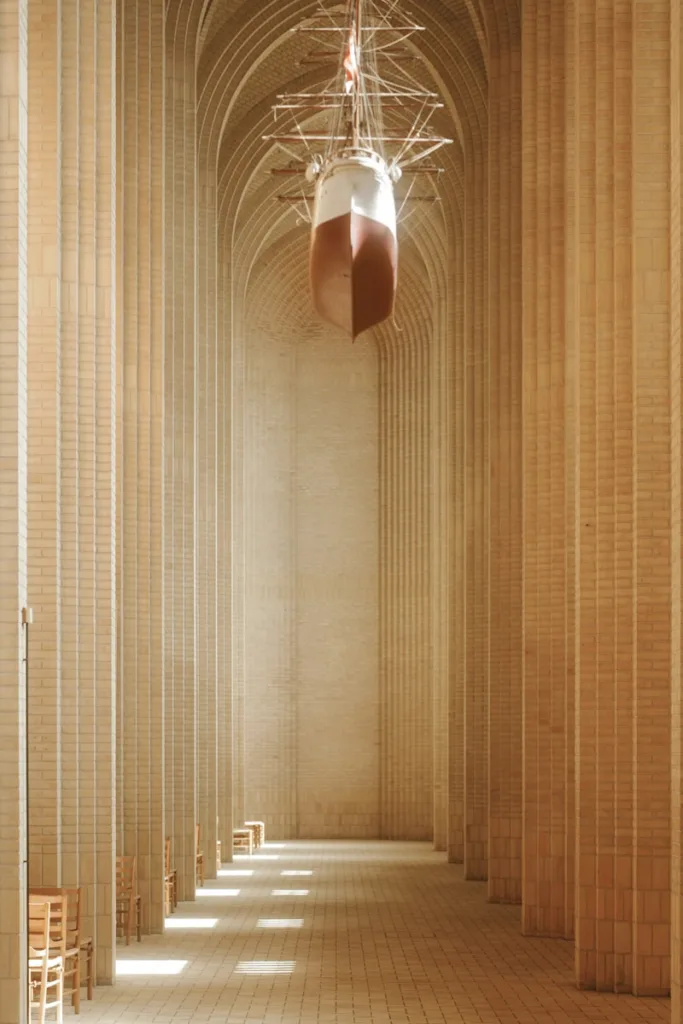 Model ship suspended in a grand, arched hall.